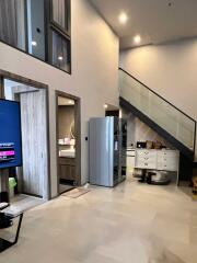 Modern living area with high ceilings and staircase