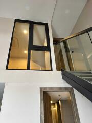 Modern stairwell with glass railing and large window