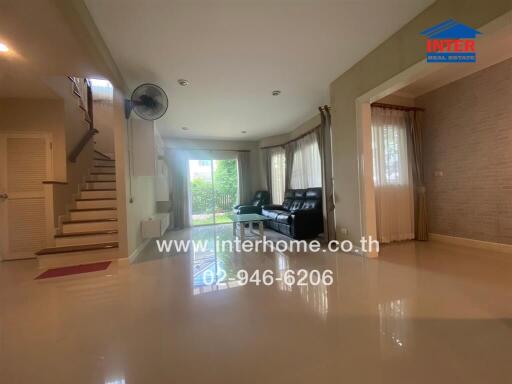 Spacious living room with natural light, modern sofa, and view of garden