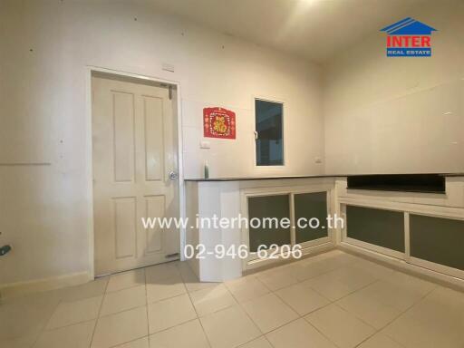 Moderately lit kitchen interior with tiled flooring and storage cabinets