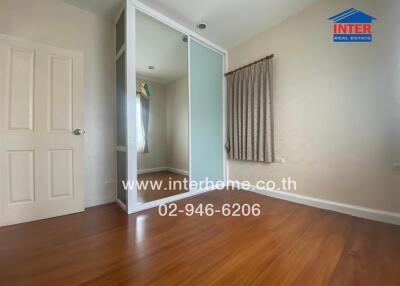 Bedroom with hardwood floors and a sliding-door closet