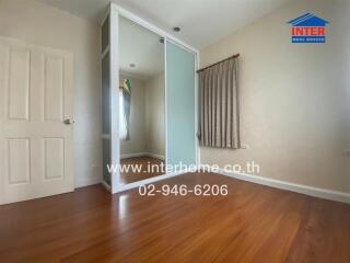Bedroom with hardwood floors and a sliding-door closet