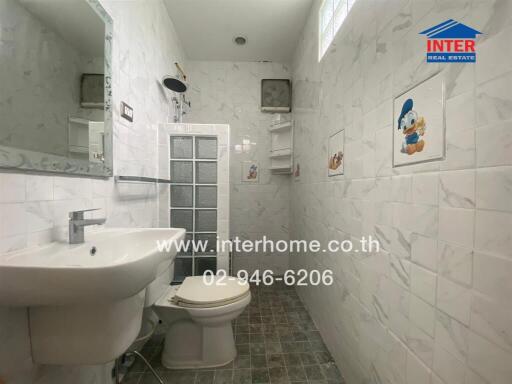 Bathroom with white tiled walls, toilet, and sink