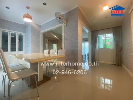 Modern dining area with a table and chairs, adjacent to a bright living room