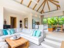 Spacious living room with modern decor, wooden beams on ceiling, open plan kitchen, and dining area with a view of greenery