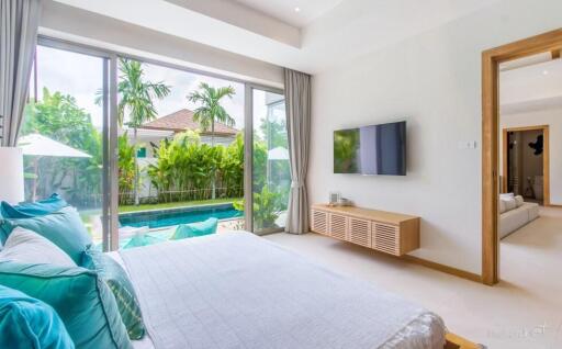 Spacious bedroom with large sliding glass doors opening to a pool view