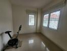 empty room with two windows and an exercise bike