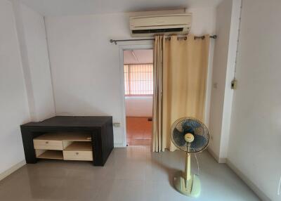 Simple living room with air conditioner, curtain, and furniture