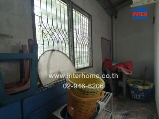 Photo of a laundry room with barred windows and various items scattered