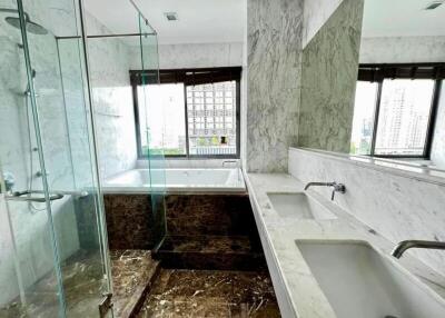 Spacious bathroom with marble finishes and glass-enclosed shower