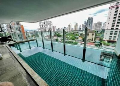 Modern rooftop infinity pool with city view