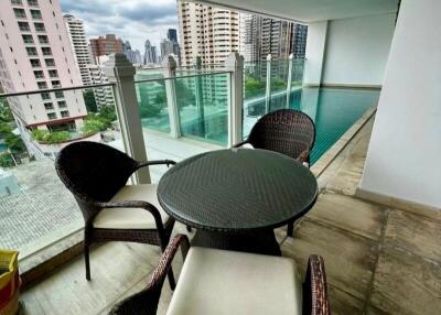 Modern balcony with city view, outdoor seating, and a narrow swimming pool
