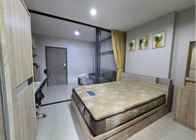 Bedroom with wooden furniture and sliding glass door to living room