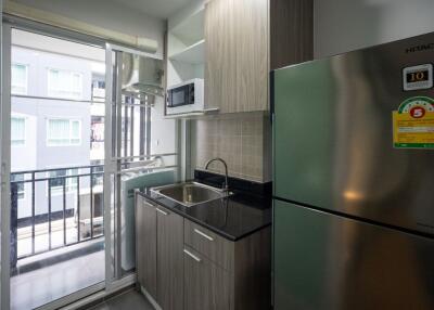 Modern kitchen with stainless steel refrigerator and balcony