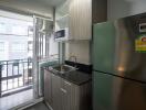 Modern kitchen with stainless steel refrigerator and balcony