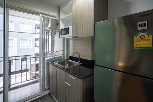 Modern kitchen with stainless steel refrigerator and balcony