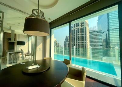 Modern dining area with pool view and cityscape