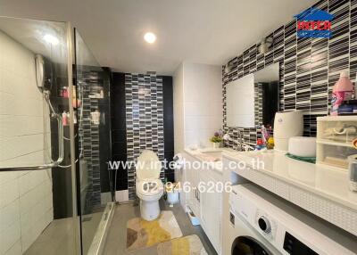 Modern bathroom with shower, toilet, sink, washing machine, and mirror