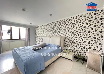 Well-lit bedroom with floral wallpaper and modern furnishings