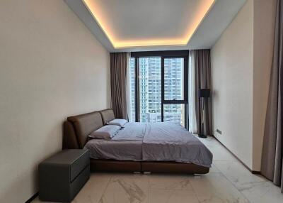 Modern bedroom with a large window overlooking city buildings