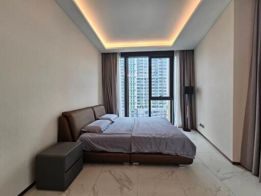 Modern bedroom with a large window overlooking city buildings