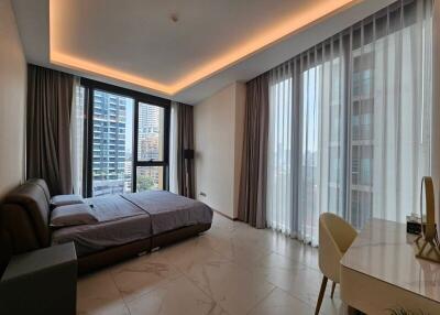 Modern bedroom with large windows, bed, and desk