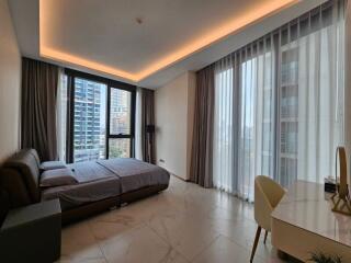 Modern bedroom with large windows, bed, and desk