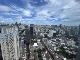 Panoramic view of a city with numerous high-rise buildings under a partly cloudy sky