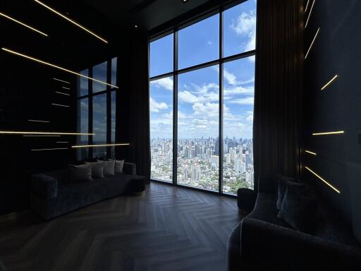 Living room with large floor-to-ceiling windows offering city view