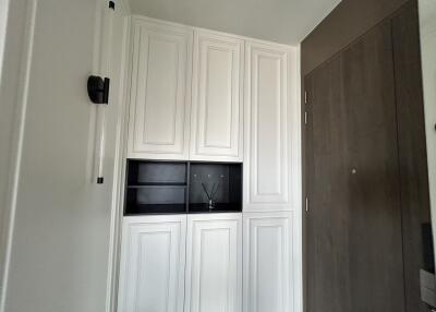 Entryway with wooden door and white cabinets