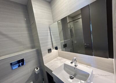 Modern bathroom with a sink, large mirror, and a shower