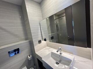 Modern bathroom with a sink, large mirror, and a shower