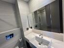 Modern bathroom with a sink, large mirror, and a shower