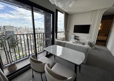 Modern living room with city view, dining table, and TV