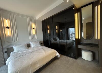 Modern bedroom with a large bed and mirrored wardrobe