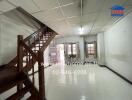 Spacious living room with staircase and tiled floor