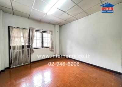 Empty bedroom with window and parquet floor