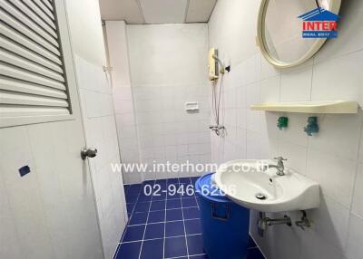 Simple bathroom with blue floor tiles and white wall tiles.