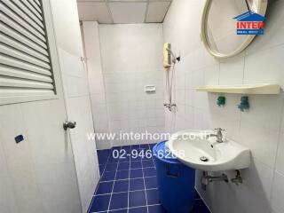 Simple bathroom with blue floor tiles and white wall tiles.