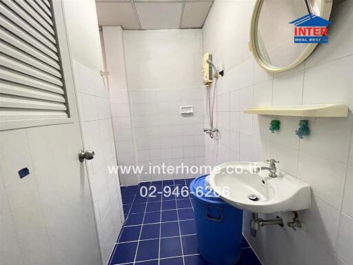 Simple bathroom with blue floor tiles and white wall tiles.