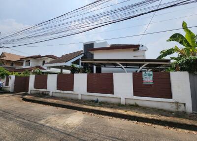 Exterior view of a modern house with a fenced yard