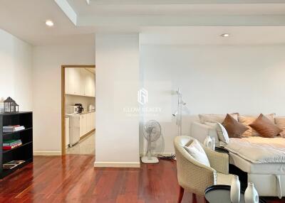 Modern living room featuring hardwood floors with an adjacent view of a kitchen