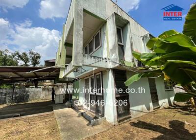 Two-story residential building with yard and banana plants