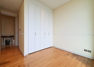 Spacious bedroom with wooden flooring and a large built-in wardrobe