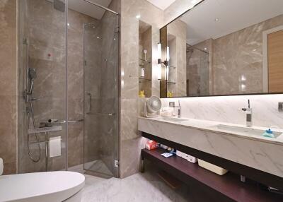 Modern bathroom with glass shower, large mirror, and marble countertop