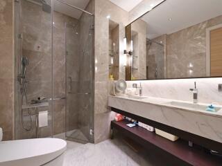 Modern bathroom with glass shower, large mirror, and marble countertop