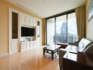 Spacious living room with large windows, city view, and modern furniture