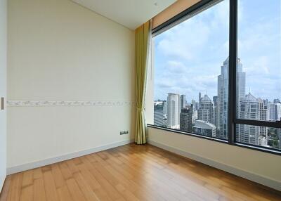 Bedroom with large window offering city view.