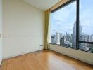 Bedroom with large window offering city view.