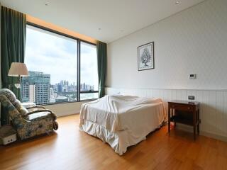 Spacious bedroom with large window and city view